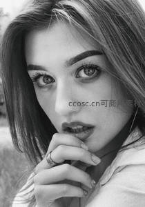 黑白特写中，女孩指尖轻触唇边，眼神迷离