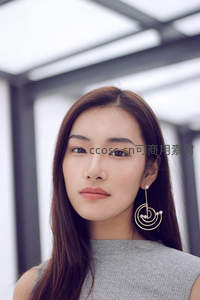 现代建筑下佩戴艺术耳环的优雅女性