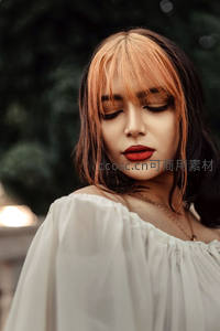 橙黑渐变发色女子闭目沉思，红唇优雅