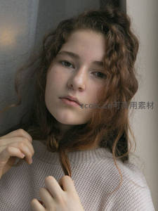 卷发少女倚墙温柔凝望