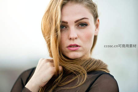 金发女子轻抚秀发回眸
