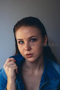 牛仔外套女子手抚衣领凝望