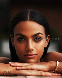 手臂纹身与金色手镯的凝视