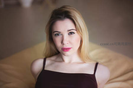 卧室中金发女子直视镜头的静谧时刻