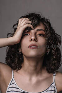 卷发女孩手抚额头凝视镜头