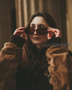 女子戴墨镜整理发型姿态优雅