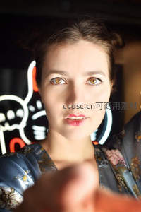 霓虹灯下凝视镜头的年轻女子