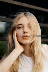 金发少女轻抚脸颊迎风