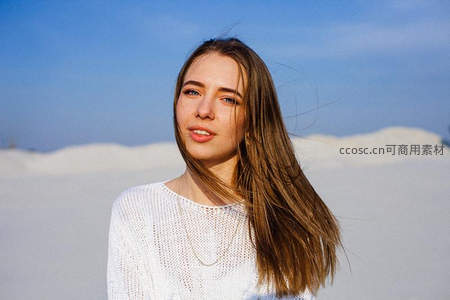 沙滩上的微笑少女，长发随风轻扬