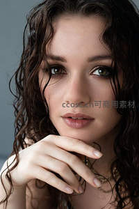 湿发美女手托下巴，眼神温柔而专注