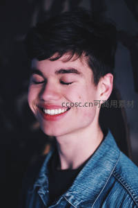 微笑少年闭眼享受，牛仔外套添随性魅力