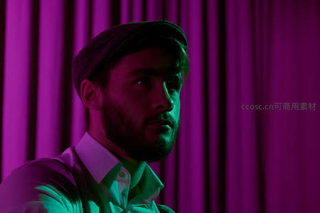霓虹灯下侧脸沉思男子
