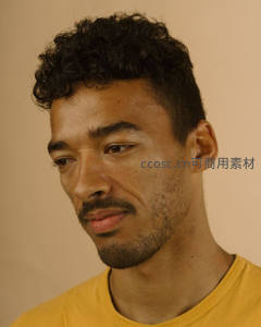 卷发青年凝视远方，黄色T恤显活力