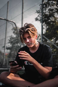 少年球场边玩手机