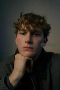 卷发青年托腮沉思室内人像