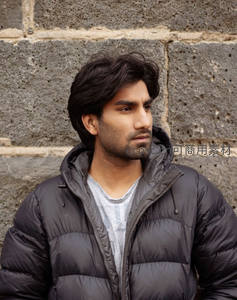 石墙前沉思的青年男子