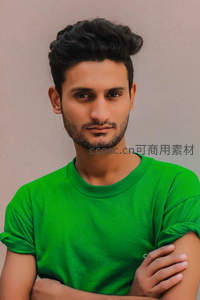 绿衣青年双臂交叉，简约背景下的自信