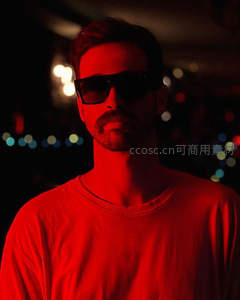 红光下的酷帅男子，墨镜遮面显神秘