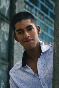 城市街头的微笑少年，背景是涂鸦墙