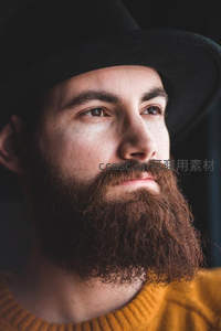 戴帽胡须男侧脸特写，沉思神情有型