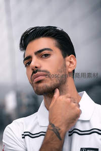 白衫男子手托下巴，都市背景显帅气