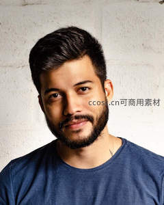 微笑男子白色砖墙前肖像