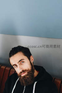 留络腮胡的男子靠在长椅上凝视