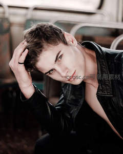 黑皮衣青年地铁车厢内低头整理发型