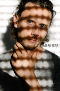 光影交错下的深邃蓝眼男子