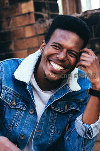 砖墙前开怀大笑的黑人青年