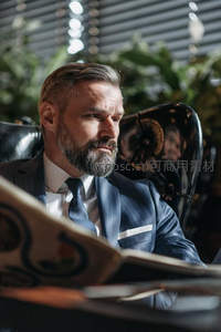 西装绅士阅读报纸办公场景