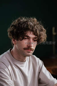 卷发男士深色背景沉思特写