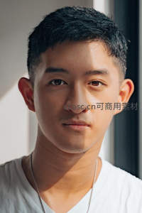 窗边阳光下的亚洲青年特写