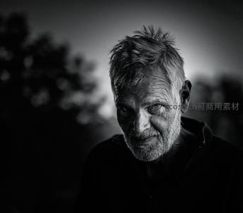 暮色中的老人，眼神锐利直视镜头