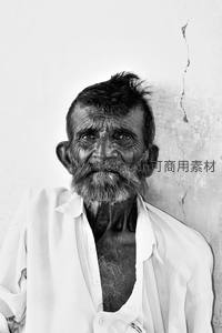 白墙前的瘦削老者，胡须斑白眼神坚定