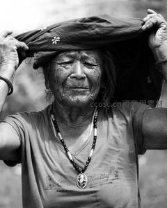 黑白影像中老人头顶布料神情沉静