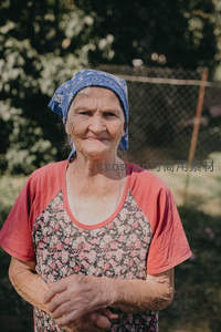 乡间老妇头戴蓝巾微笑望向镜头