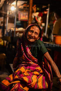 市集灯火下，笑容灿烂的老妪