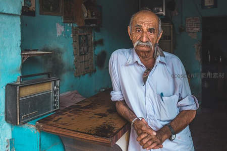蓝墙老店前，白须老者静立凝望