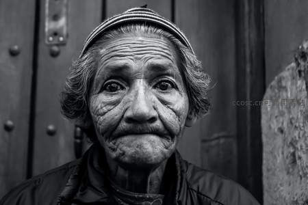 木门之前，皱纹如沟壑的老婆婆直视镜头