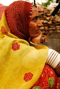 印度妇女侧颜凝望，黄纱红巾显传统风韵