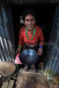 村妇捧锅迎客，门框光影中展淳朴笑容