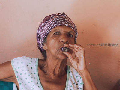 头巾妇人品烟斗，墙边闲适