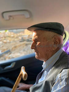 车内侧颜的老者手握拐杖望窗外