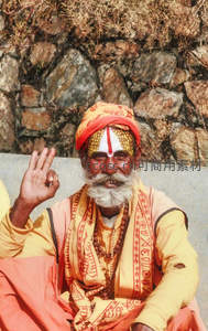 印度苦行僧微笑挥手，额头绘有宗教符号