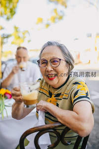 银发奶奶举杯欢笑，户外咖啡时光温馨惬意