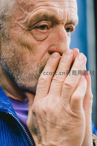 沉思老人手掩口鼻凝视远方
