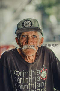 戴棒球帽穿球队T恤的老人凝视