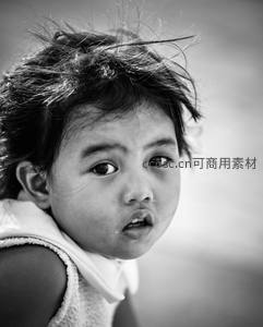 黑白特写中眼神清澈的孩子，发丝凌乱显纯真