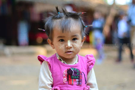 异域风情女童面绘星纹，身着粉裙